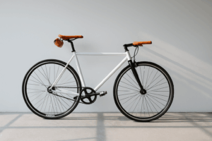 Close-up of a black bicycle seat and wheel locked to a rack with Denver skyline blurred at sunset.