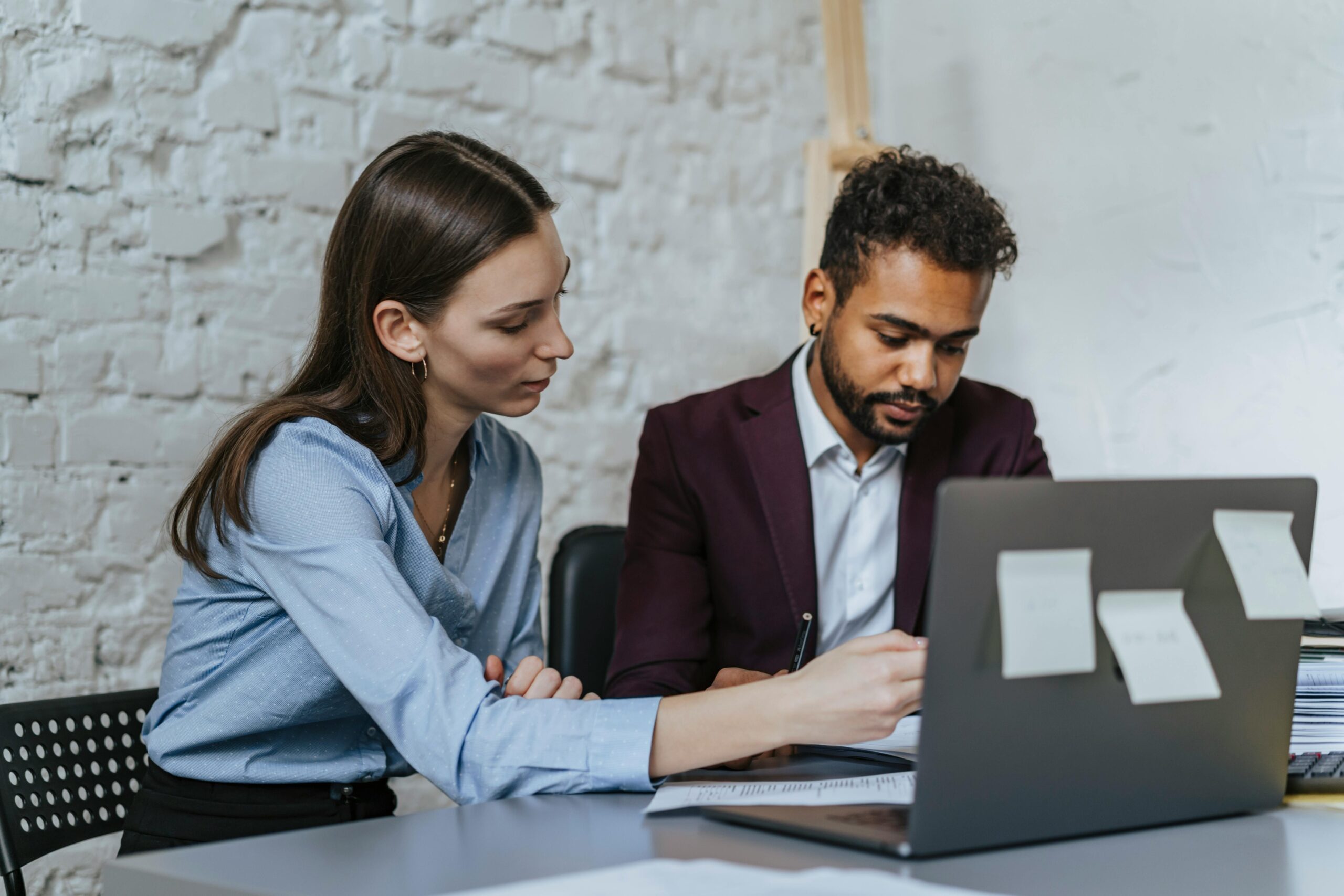 A man and woman meeting at a desk reviewing documents during a legal consultation