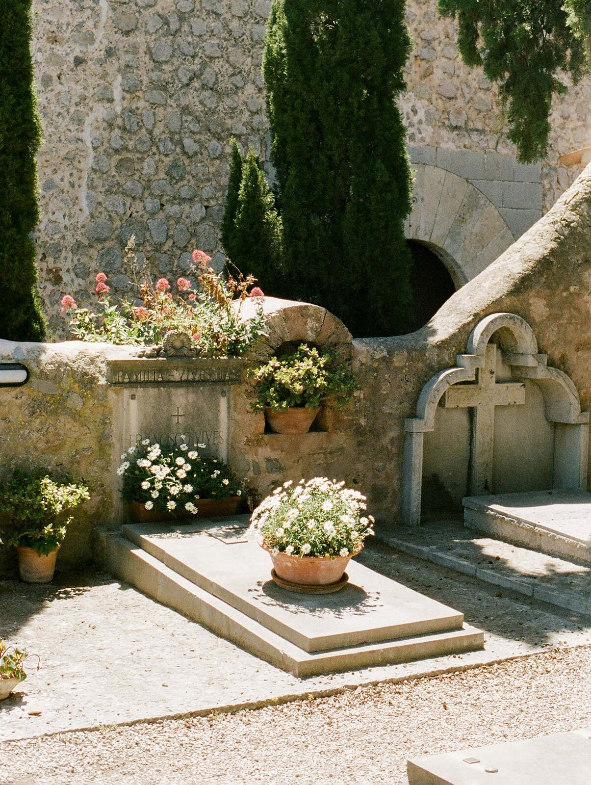 Tumbas floridas en un cementerio de piedra