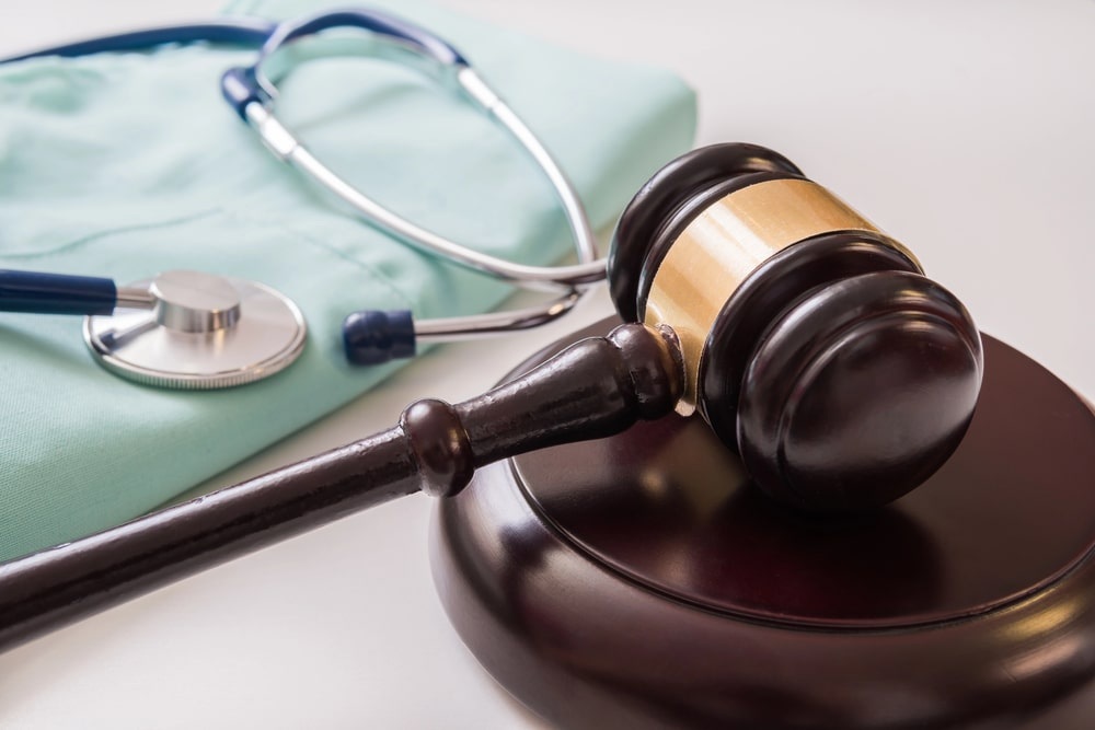 Stethoscope and wooden gavel on a desk
