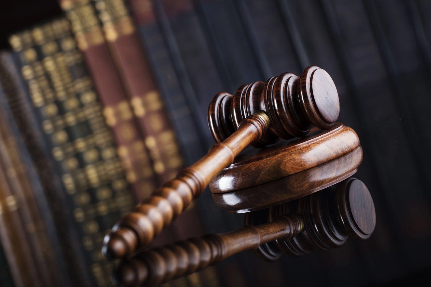 Mazo de madera apoyado frente a libros de leyes.